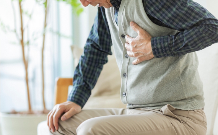 Man clutching chest, showing signs of possible chest pain